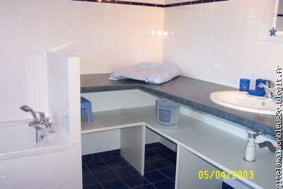 Salle de bains avec baignoire et lavabo, table à langer et baignoire b